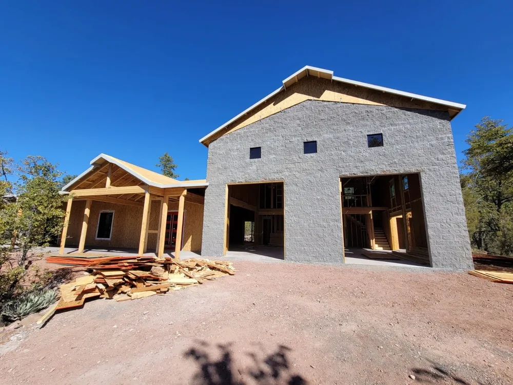 Custom home under construction with a tall central volume and covered entry
